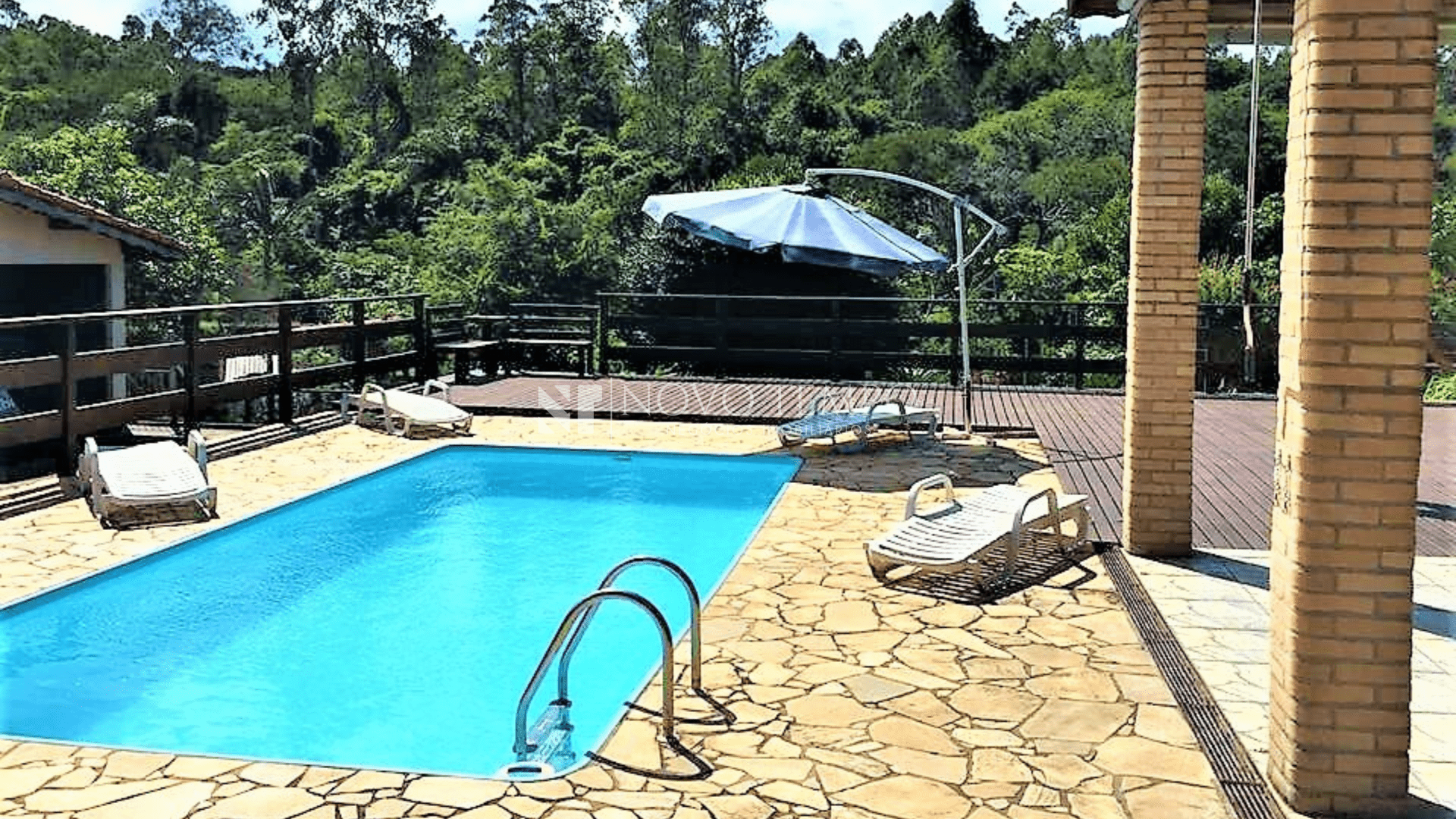 Fachada da chácara no Bairro Pinhal, Cabreúva — terreno de 4.140 m² e arborização; Varanda gourmet em L completamente equipada com churrasqueira, forno industrial e toldos — ideal para eventos; Área gourmet com forno à lenha e espaço de convivência na chácara à venda em Cabreúva; Piscina com deck e vista para o lago — lazer e contemplação; Lago com peixes na chácara do Bairro Pinhal, Cabreúva; Edícula e casa de caseiro independentes — suporte para hóspedes e funcionários; Sala integrada e cozinha da casa principal — ambientes amplos e funcionais; Vista aérea da chácara e entorno verde no Bairro Pinhal.